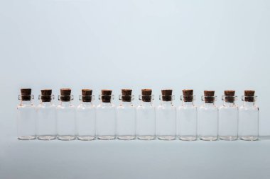 Mantarlı cam şişeler açık mavi arkaplanda izole edilmiş..