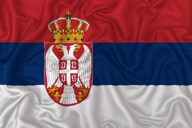 Sırbistan ülke bayrağı dalgalı ipek kumaş arka planında.