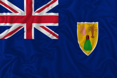 Dalgalı ipek kumaş arka planında Türkler ve Caicos Adaları bayrağı.
