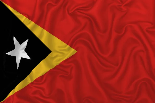 波状の絹織物の背景に東ティモールの国旗 — ストック写真