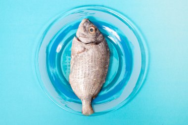 Çiğ yaldızlı balık bambu hasırının üstünde.