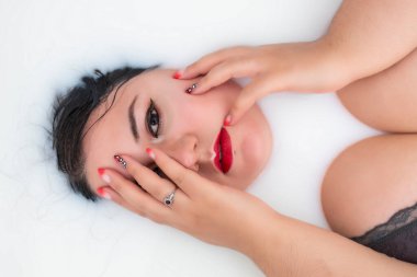 Sütlü küvette seksi iç çamaşırları giyen bir kadın..