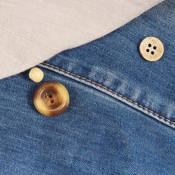 Buttons on the background of canvas and jeans clothes close up
