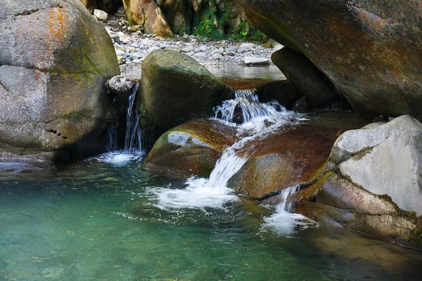 Small beautiful waterfall among the rocks of the mountain creek