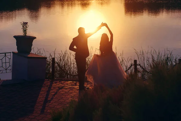 Amorevole coppia che balla al tramonto sullo sfondo dell'acqua — Foto Stock