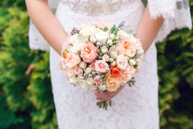 Gelin düğün töreninde büyük bir buket tutuyor.