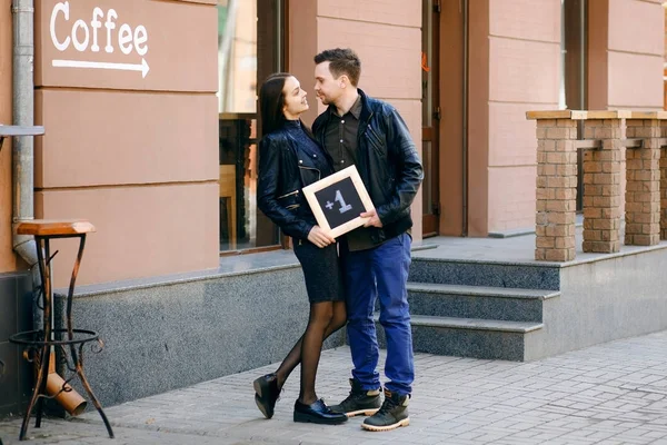 mutlu bir evli çift sokakta duran ve siyah plakalı bir yazıt artı bir holding