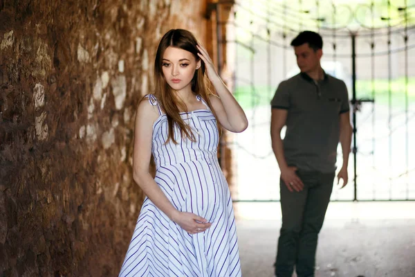 Pareja joven, chica embarazada muy de moda, pareja enamorada en túnel de piedra — Foto de Stock