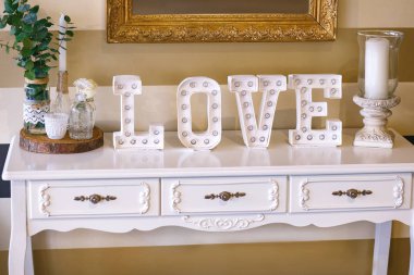 Beyaz harflerle yazılmış aşk, beyaz tasarımcı mobilyaları.