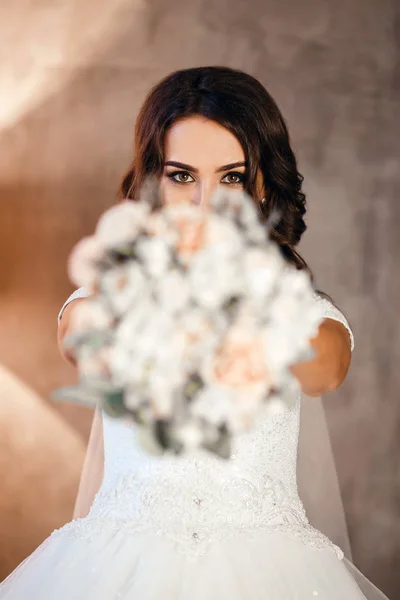 Noiva se divertindo e se escondendo atrás de um buquê de flores bonitas, foto vertical — Fotografia de Stock