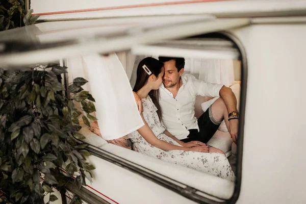 Gyönyörű fiatal pár ölelkezik egy lakókocsiban. — Stock Fotó