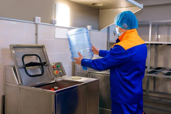 Bir içme suyu arıtma tesisi, bir fabrika işçisi plastik şişeyi inceler, temizliği izler, içme suyu tesisi, plastik işleme, temiz su sağlık garantisidir