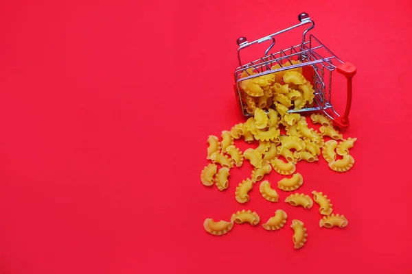 Pasta Een Mini Winkelwagentje Een Rode Achtergrond Plaats Voor Tekst — Stockfoto