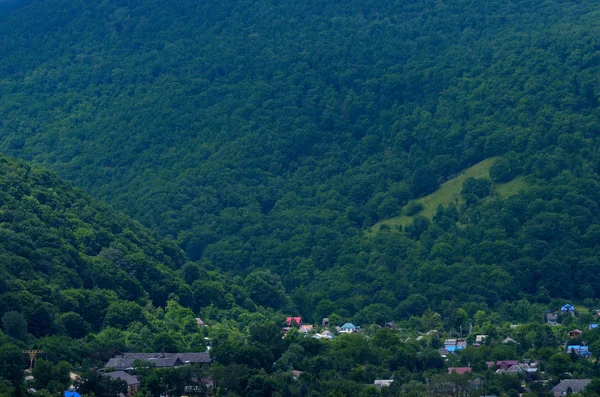 Vesnice na pozadí zelené hory. Krásné r — Stock fotografie