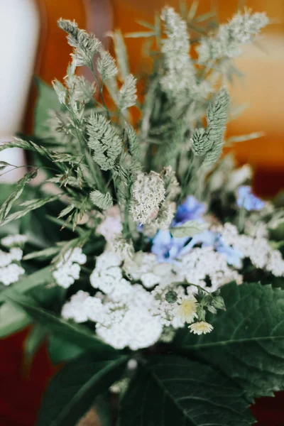 Tahta masadaki kır çiçekleri. Mavi ve beyaz çiçekler.