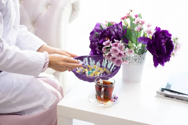 tea cup table magazines flowers girl puts sugar in tea