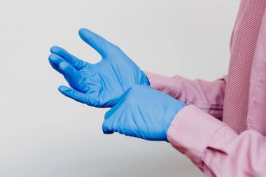 Adam tıbbi eldiven takıyor.