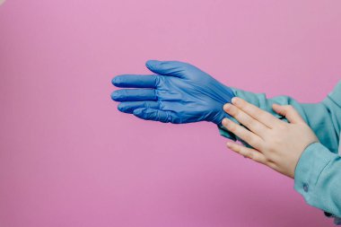 Kız tıbbi eldiven takıyor.