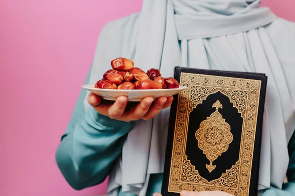 戴头巾的穆斯林女孩拿着日期和古兰经 — 图库照片
