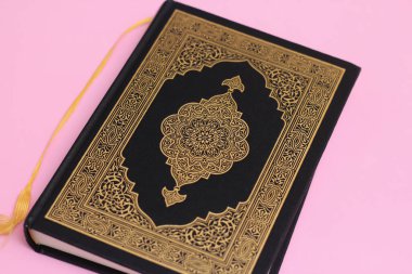 Pembe arka planda bir yer imine sahip kapalı Kur 'an