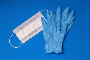 Mavi arka plan için tıbbi eldiven ve maske.