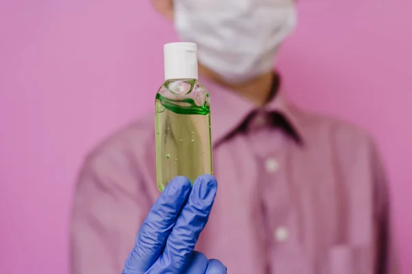 Hombre Guante Médico Sostiene Una Botella Antiséptico Desinfectante Fondo Rosa — Foto de Stock