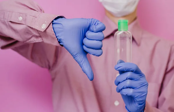 Egy Fickó Orvosi Kesztyűben Tart Egy Üres Fertőtlenítőt Hüvelykujj Rózsaszín — Stock Fotó