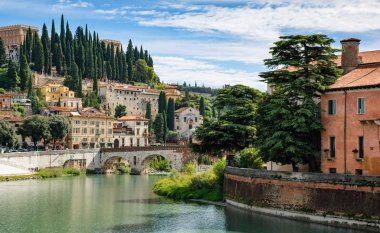 Verona, İtalya - 24 Eylül 2019: Verona, İtalya 'daki Roma Tiyatrosu ve Nehri manzarası. Roma Tiyatrosu Arkeoloji Müzesi (Museo Archeologico al Teatro Romano) ve St. Pietro şatosu manzarası.