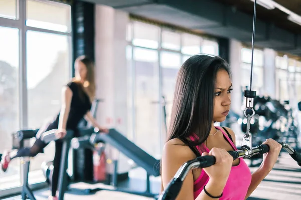 Sport a fiatal nők gyakorlatok az edzőteremben, Lat gép — Stock Fotó