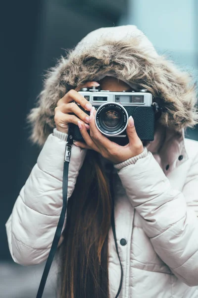 Beautiful girl photographing in cold weather, urban environment — Stock Photo, Image