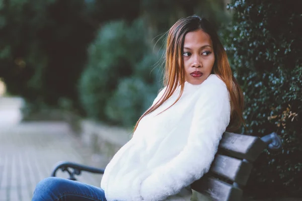 Menina sentada no banco no parque da cidade — Fotografia de Stock