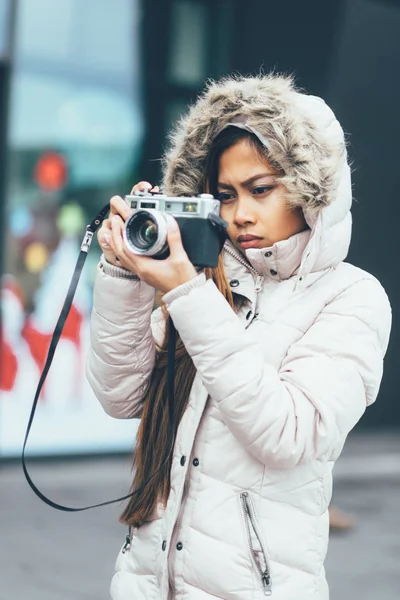 Beautiful girl photographing in cold weather, urban environment — Stock Photo, Image