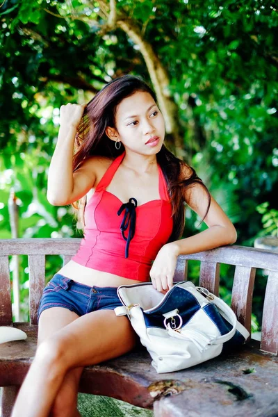 美丽的年轻女子，与袋坐上板凳，暑假的肖像 — 图库照片