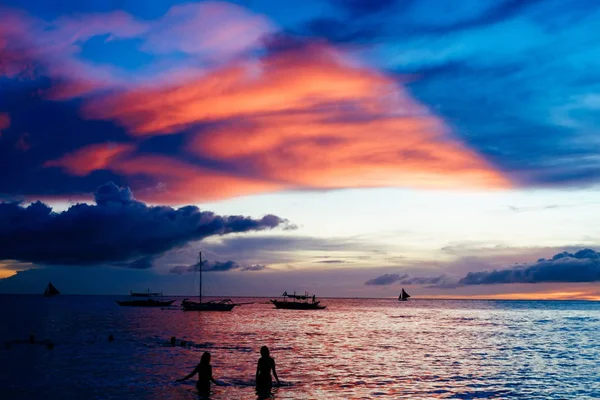 Hermoso atardecer colorido sobre barcos de pesca y personas en el agua — Foto de Stock