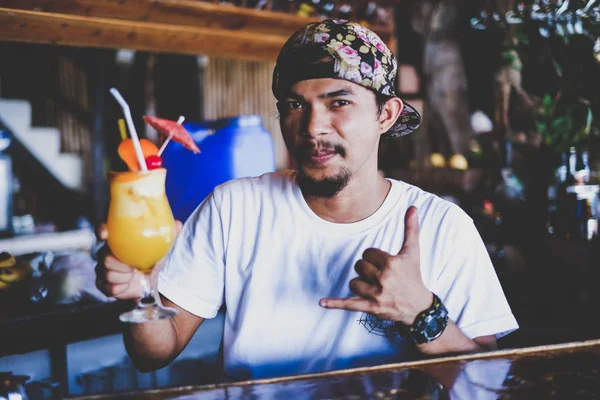 Ung asiatisk bartender man med orange cocktail — Stockfoto