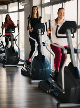 Kayak makine ile spor salonunda egzersiz genç güzel kız