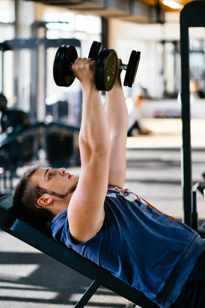 Fiatal jóképű férfi dolgozik súlyzók, fitnesz-kondi terem — Stock Fotó