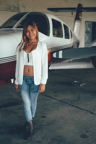 Belo retrato feminino no hangar do avião, com aeronaves modernas — Fotografia de Stock