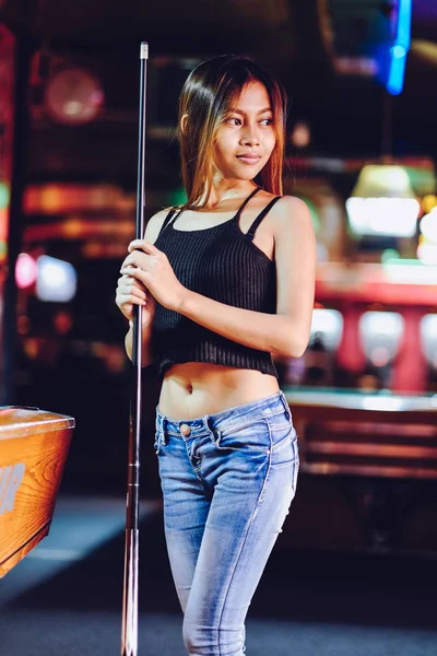 Menina bonita nova em um clube de bilhar, com cue stick posando — Fotografia de Stock