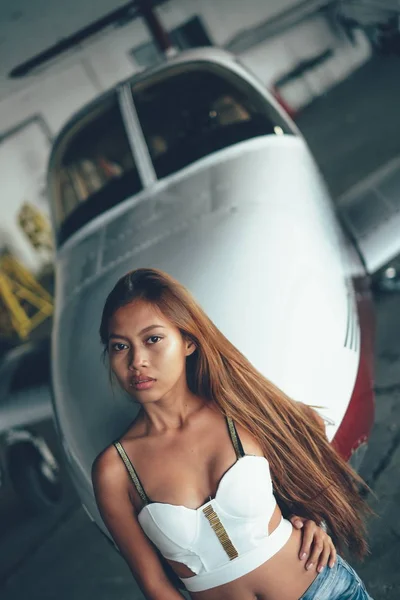 Красивый женский портрет в ангаре самолета, с современным самолетом — стоковое фото