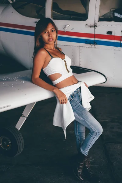 Belo retrato feminino no hangar do avião, com aeronaves modernas — Fotografia de Stock