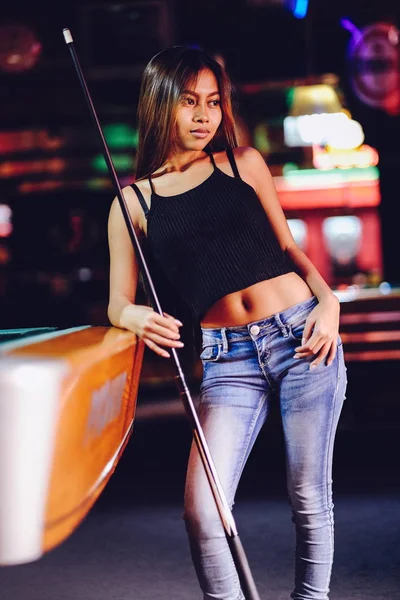 Menina bonita nova em um clube de bilhar, com cue stick posando — Fotografia de Stock