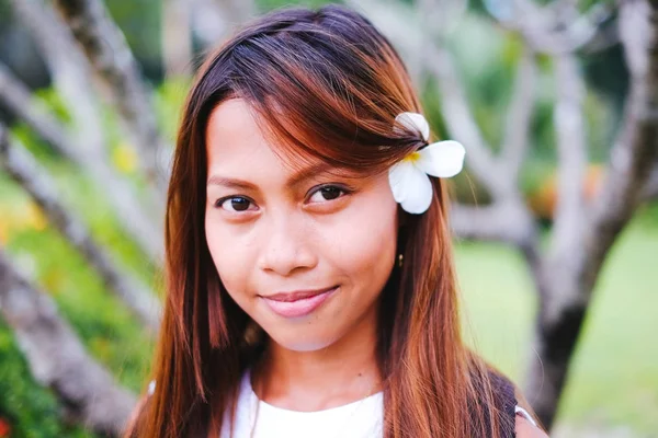 Porträtt av ung vacker flicka med frangipani, plumeria blommor på hennes hår — Stockfoto