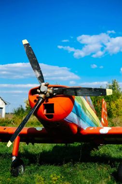 Colorful airplane parked on the grass at the airfield clipart