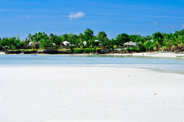 Beautiful white coral sand beach with palms and cottages, turquoise blue ocean — Stock Photo, Image