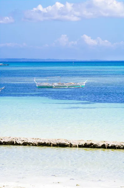 Barco de pesca vazio atracado na costa oceânica de cor turquesa perto da praia de areia branca à tarde no horizonte oceânico na Ásia — Fotografia de Stock