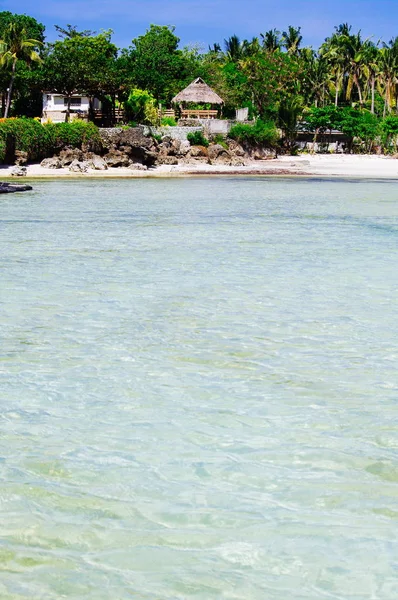 Praia de areia branca rochosa com palmas e bungalows na ilha na Ásia — Fotografia de Stock