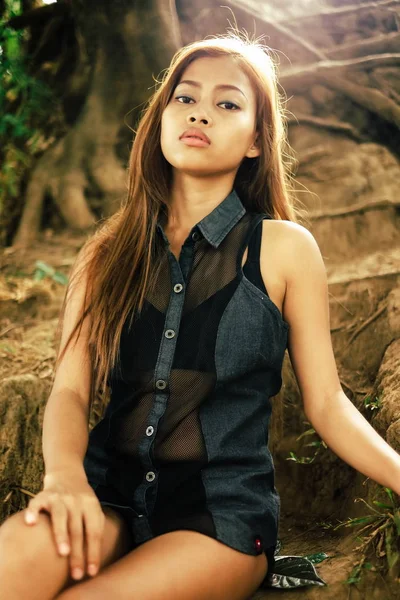 Jovem sexy, bela menina asiática sentada no chão da colina — Fotografia de Stock