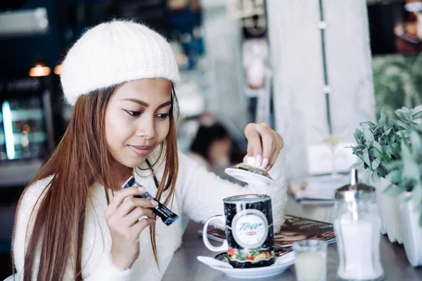 Attractive beautiful girl enjoying having a tea in a cafe. Beautiful girl winter concept