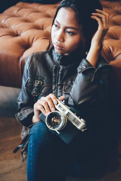 Linda jovem mulher em jaqueta de couro, segurando câmera de filme retro velho. Hipster, estilo de moda retro vintage — Fotografia de Stock